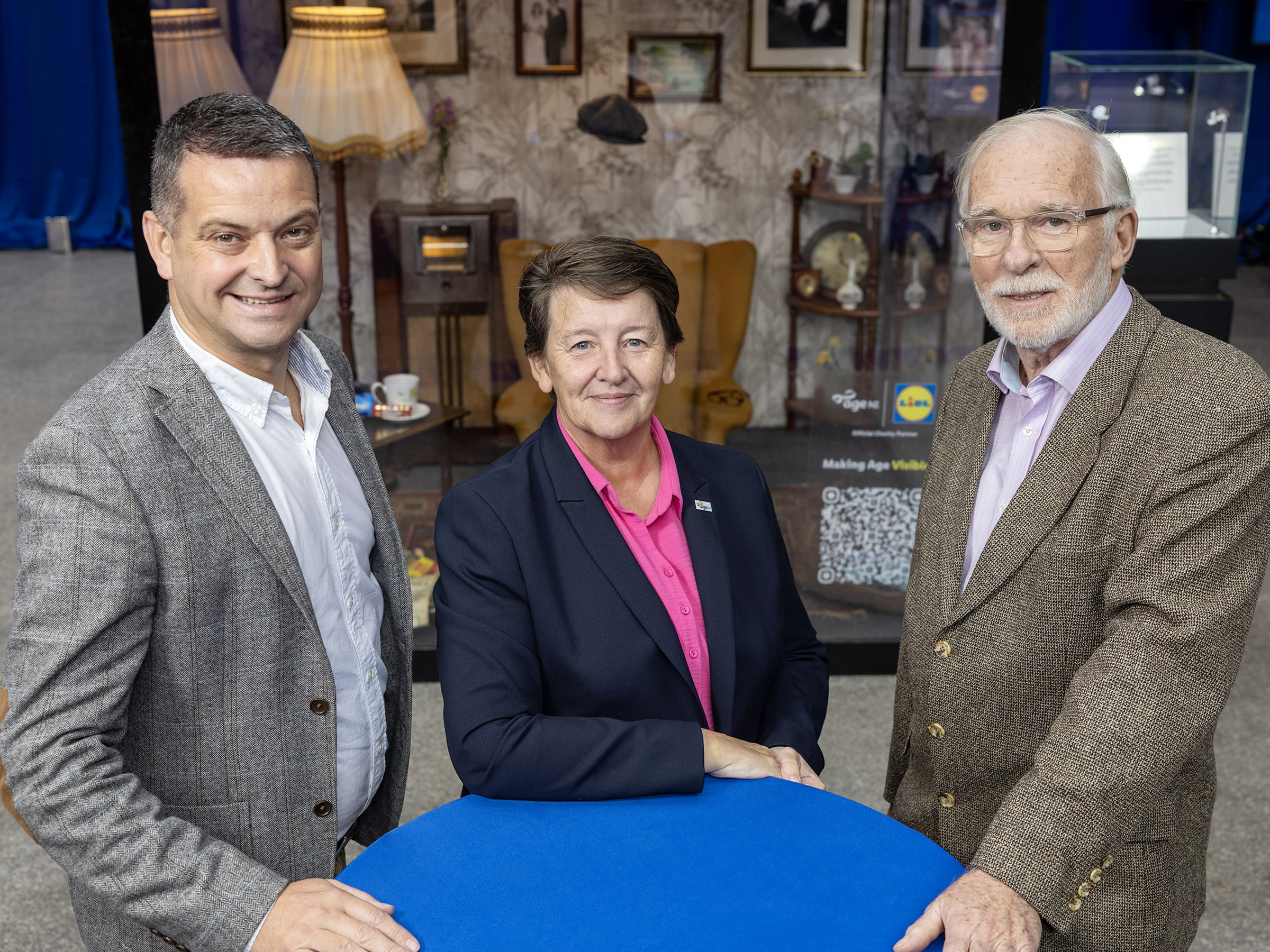 Lidl director, Age NI ceo, and actor Ian McElhinney in front of loneliness installation in shopping centre