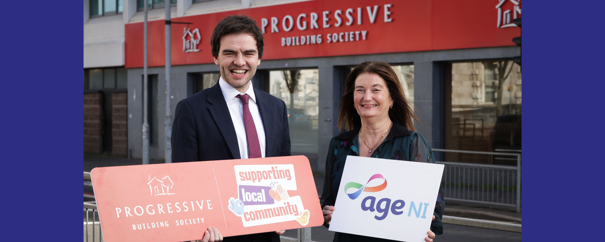 Age NI and Progressive staff holding logo boards outside Progressive building