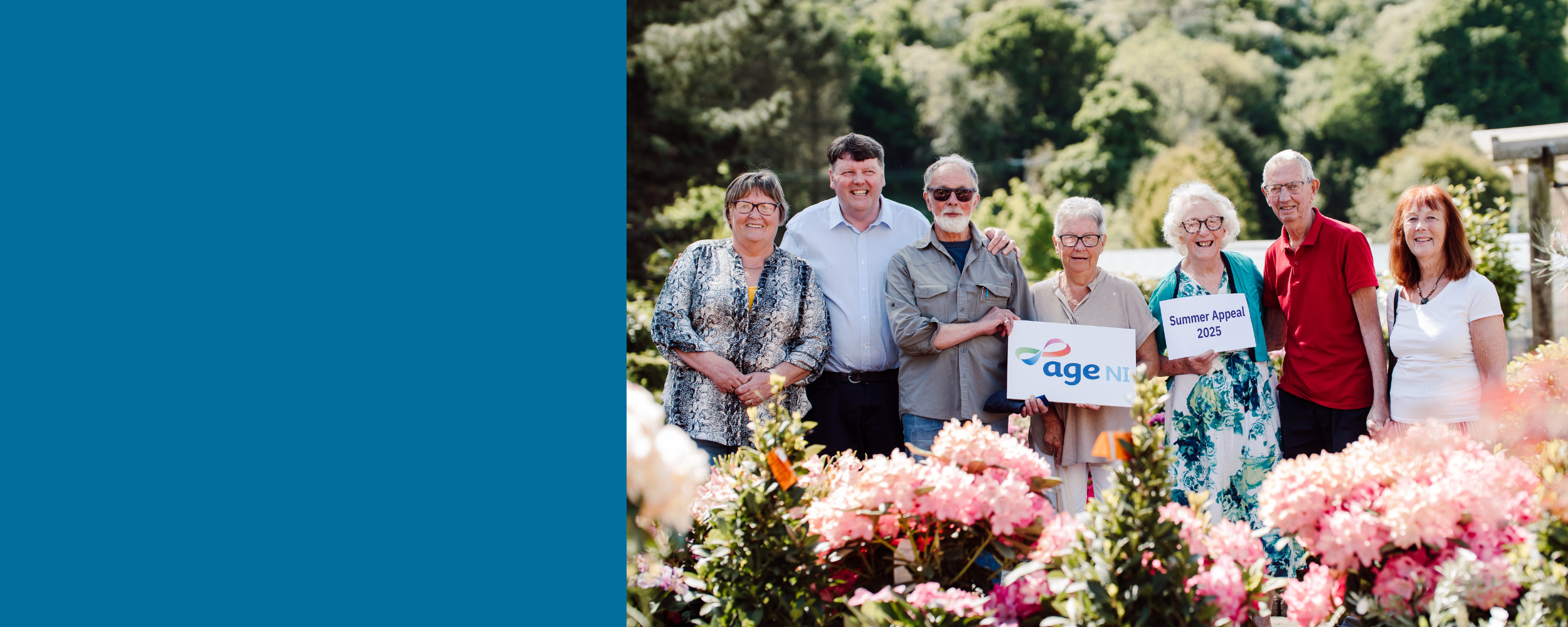 group of older people standing outside at a garden centre with flowers in the foreground, holding an Age NI logo board and sign that says Summer Appeal 2025